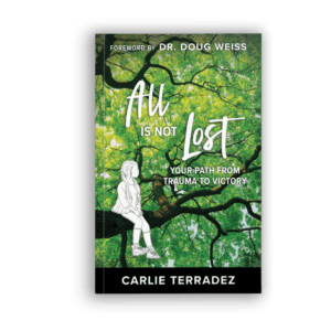 All is not lost - your path from trauma to victory book cover - girl sitting on tree branch